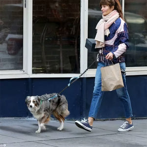 Woman using Pakch turquoise hands-free dog running leash while walking a dog in the city, showing the waist belt and hands-free design